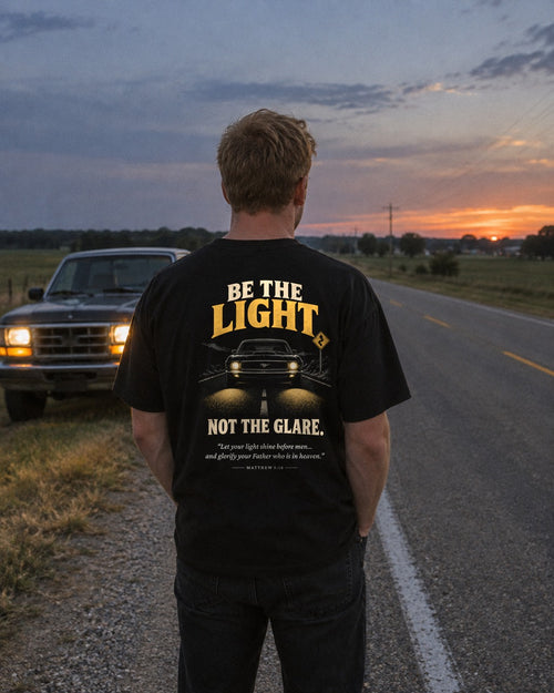 Be the Light High Beams tee on a country road, back view